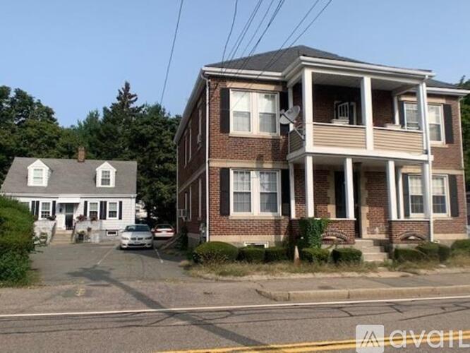 A two-story house with a car parked in front.