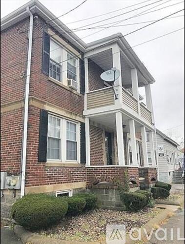 A brick house with a satellite dish on the roof.