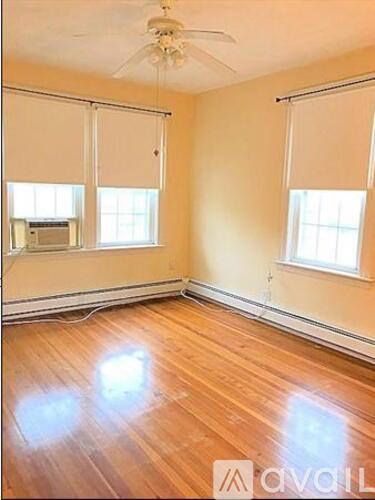 A room with wooden floors and a ceiling fan.