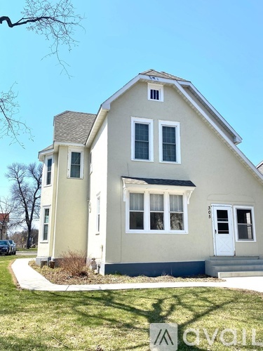 A two-story house with a white door and windows.