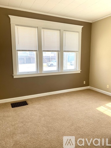 A room with a window and a car visible outside.