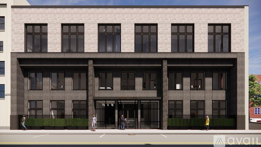 A grey building with a black awning and people standing outside.