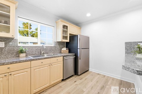A kitchen with wooden cabinets and a stainless steel refrigerator.