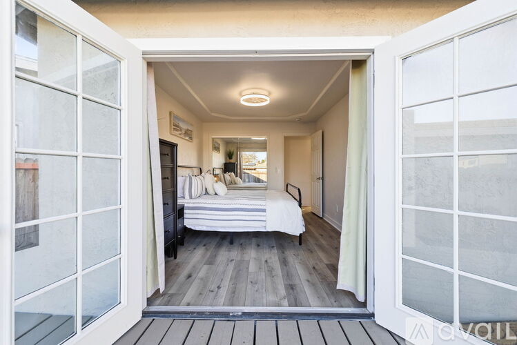A bedroom with a bed and a window with a white frame.