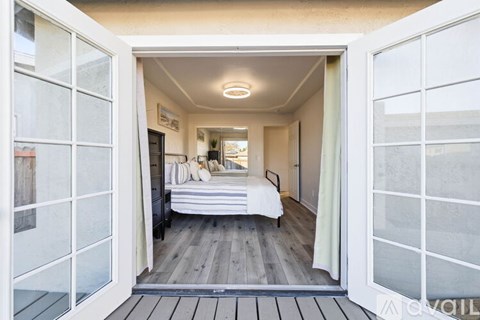 A bedroom with a bed and a window with a white frame.