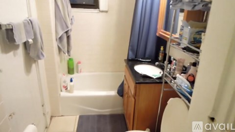 A bathroom with a white tub and a wooden vanity.