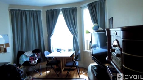 A living room with a table, chairs, and a television.
