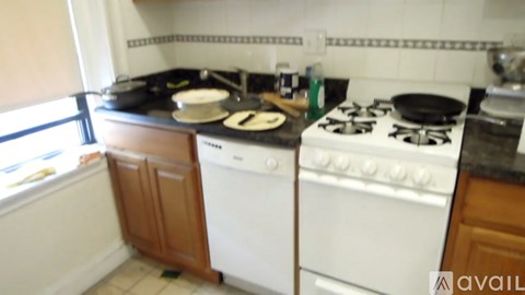 A kitchen with a white stove top oven and a white dishwasher.