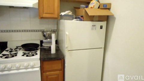 A small kitchen with a white refrigerator and a white stove top.