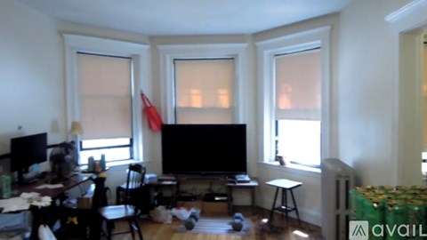 A living room with a television, chair, and desk.