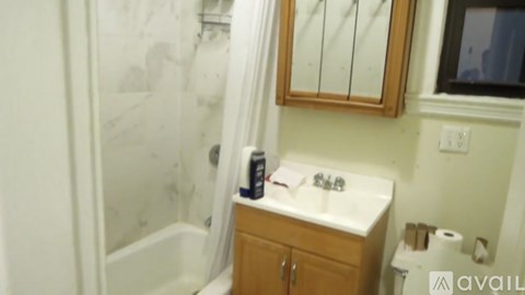 A bathroom with a sink, mirror, and toilet paper.