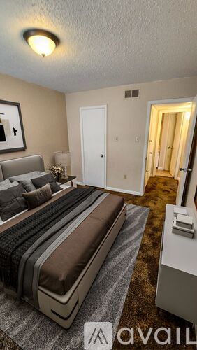 A bedroom with a large bed and a carpeted floor.