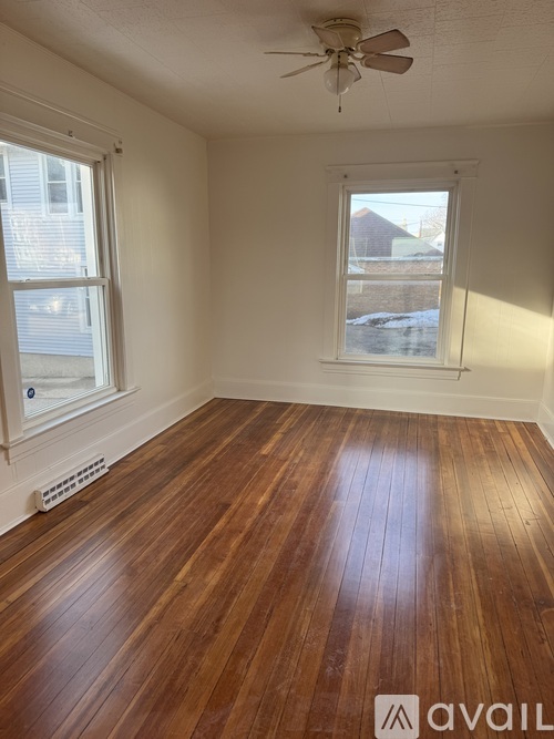 A room with wooden floors and a ceiling fan.