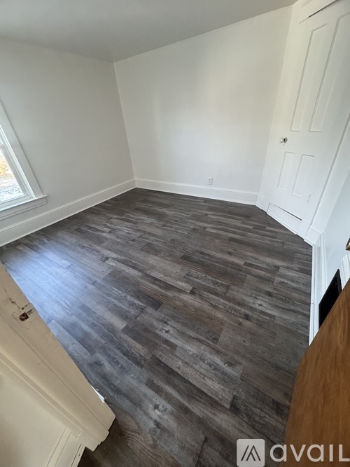 A room with a wooden floor and white walls.