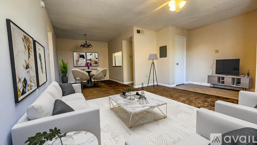 A living room with a white sofa, a coffee table, and a television.
