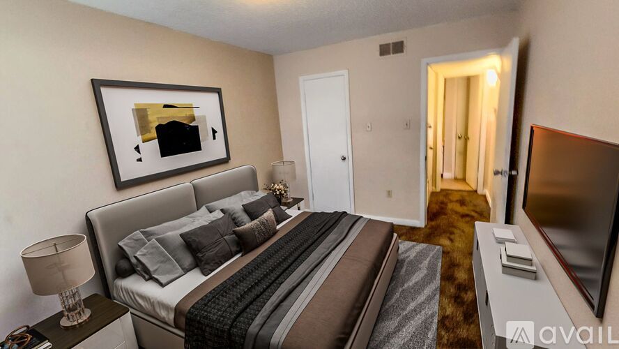 A bedroom with a large bed and a painting on the wall.