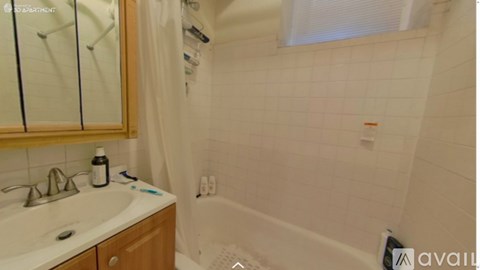 A bathroom with a white sink and a white bathtub.