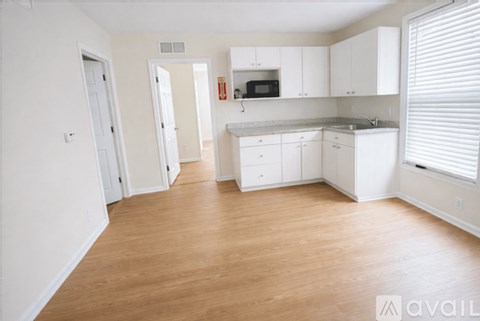 A kitchen with white cabinets and a microwave above the stove.