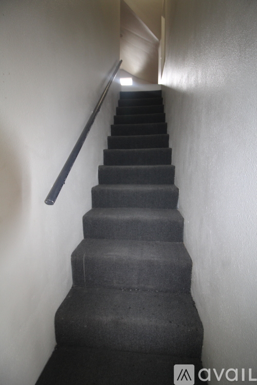A staircase with a black handrail.