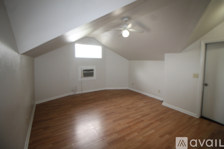 A room with wooden flooring and a window.