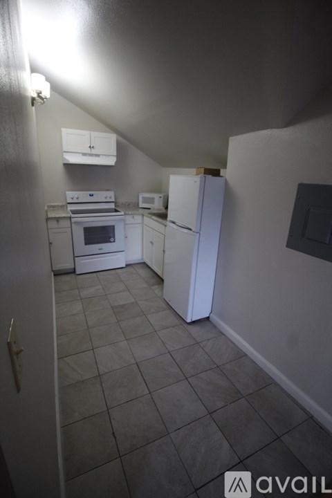 A kitchen with white appliances and a white refrigerator.