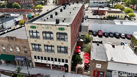 A street view of a city with buildings, cars, and a red awning.