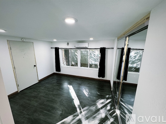 A bedroom with a bed, a television, and a ceiling fan.