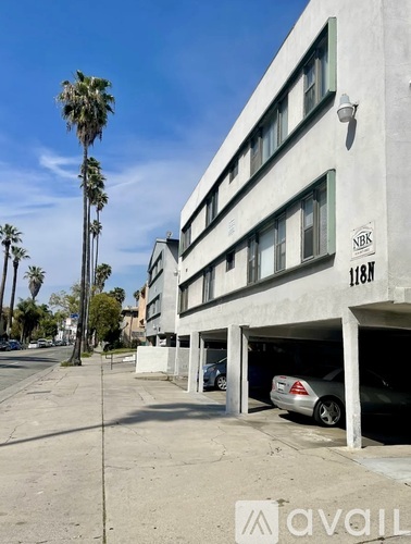 A car is parked in a garage under a building with the number 1168.