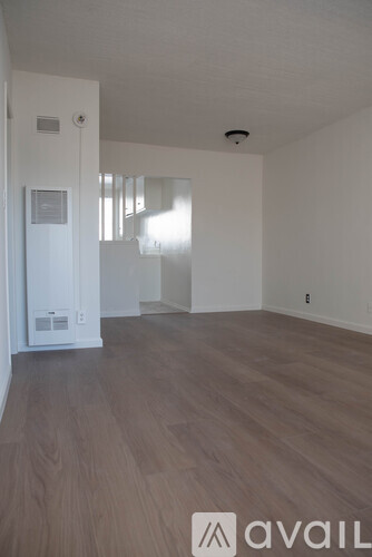 A room with wooden flooring and white walls.
