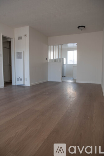 A room with wooden flooring and white walls.