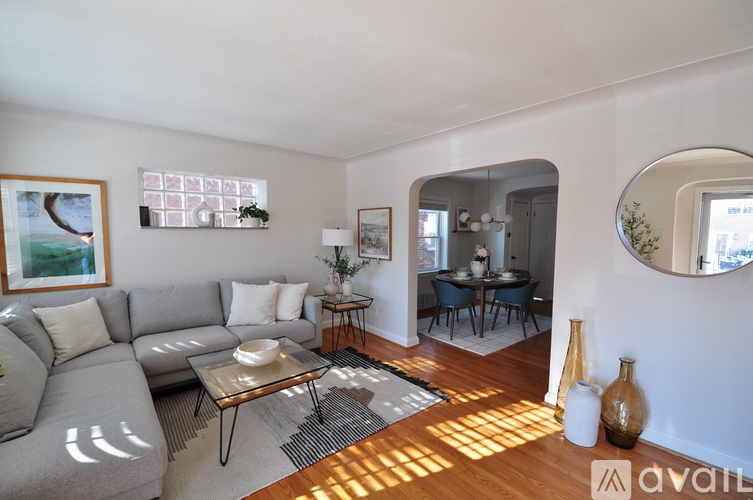 A living room with a grey couch and a coffee table in front of a large window.
