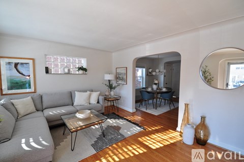 A living room with a grey couch and a coffee table in front of a large window.