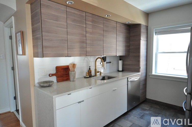A kitchen with white cabinets and a wooden backsplash.