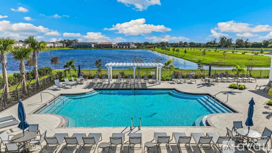 A large outdoor swimming pool surrounded by lounge chairs and umbrellas.