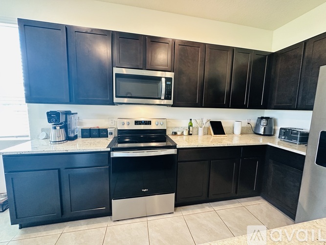 A kitchen with black cabinets and a white countertop.