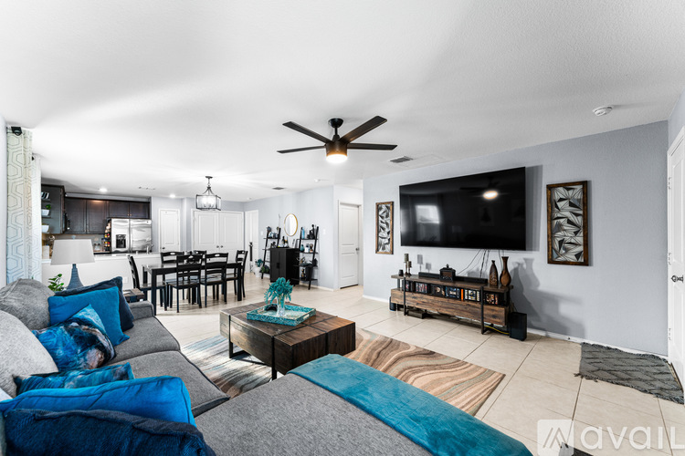 A living room with a grey couch and a blue throw pillow.