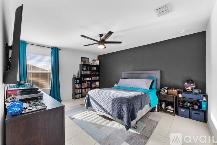 A bedroom with a bed, a ceiling fan, and a bookshelf.