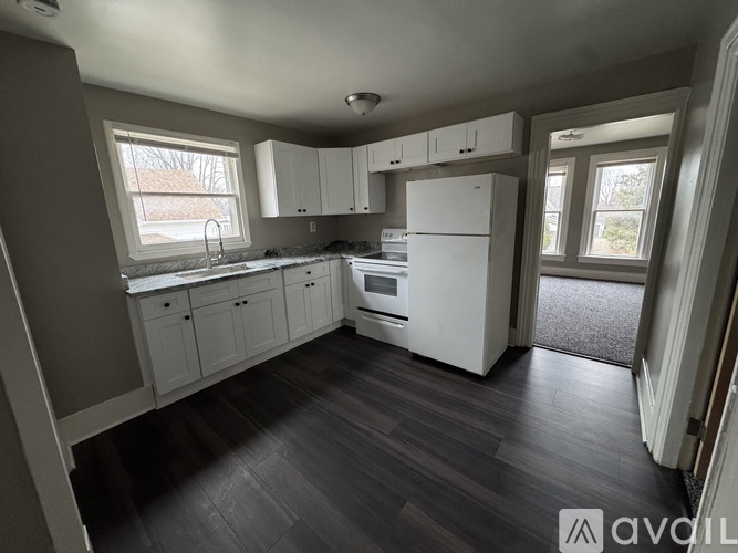 A kitchen with white appliances and cabinets.