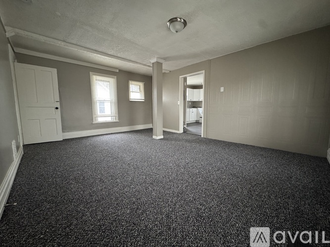 A room with grey carpet and white walls.