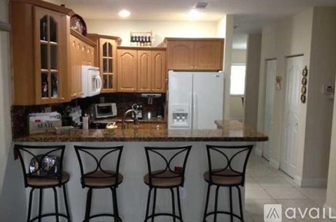 A kitchen with brown cabinets and a white fridge.