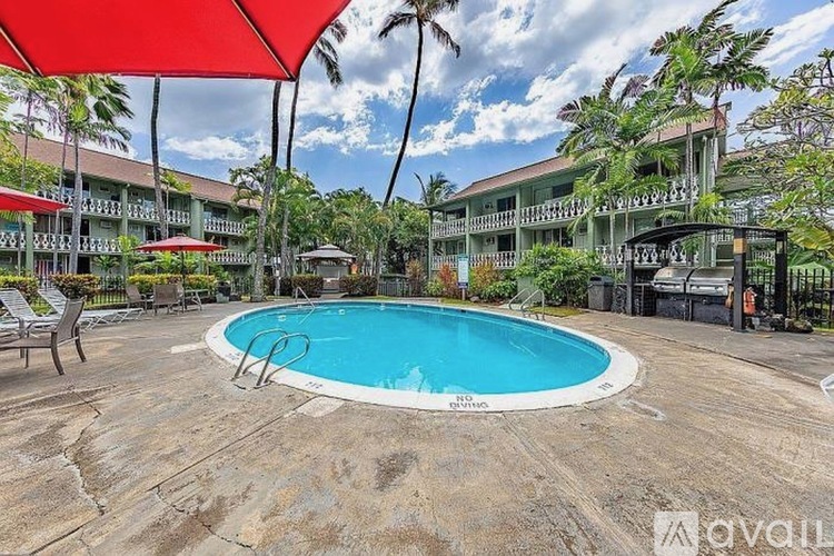 A pool surrounded by a red canopy and a building in the background.
