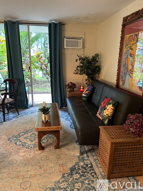 A living room with a couch, a table, and a painting on the wall.