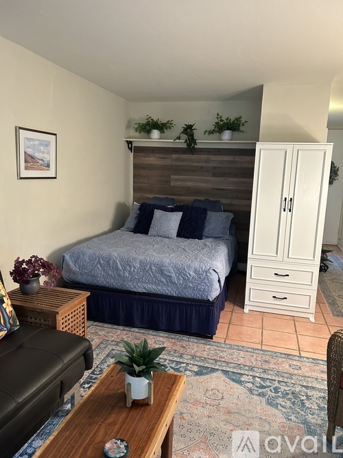 A bedroom with a bed, a cabinet, and a coffee table.