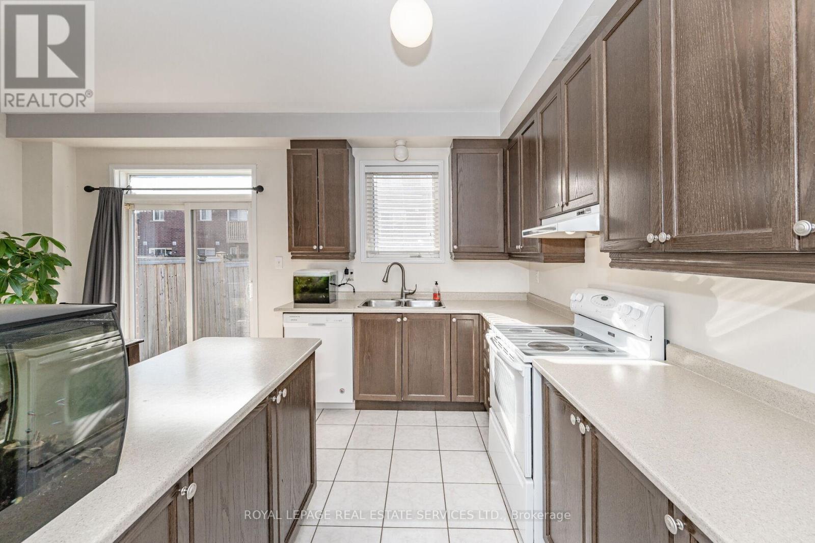 A kitchen with brown cabinets and white appliances.
