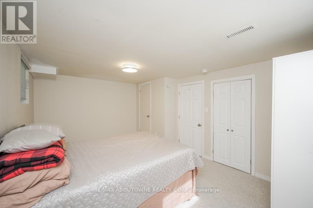 A bedroom with a bed, pillow, blanket, and two doors.