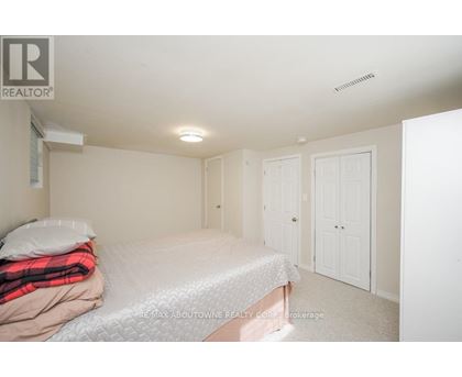 A bedroom with a bed, pillow, blanket, and two doors.