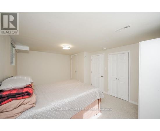A bedroom with a bed, pillow, blanket, and two doors.