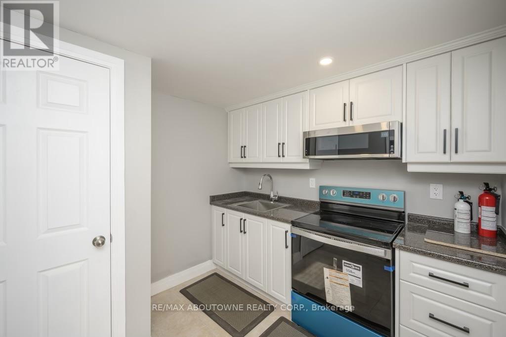 A kitchen with white cabinets and a black stove top oven.
