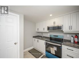 A kitchen with white cabinets and a black stove top oven.