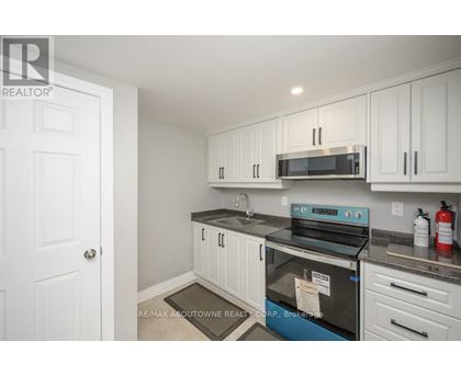 A kitchen with white cabinets and a black stove top oven.